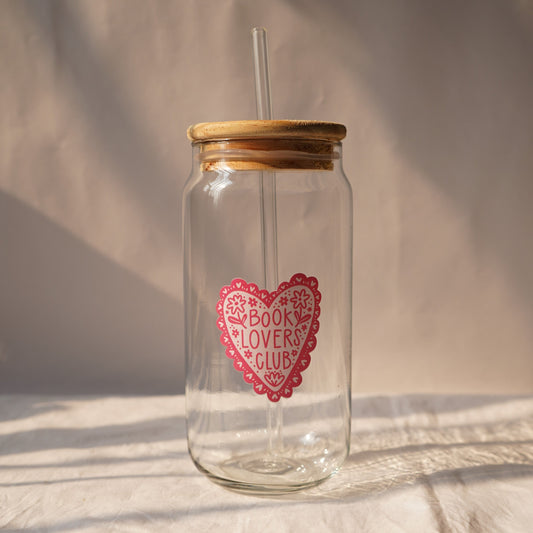 Clear glass tumbler with wooden lid and straw, featuring a pink heart design and text on a neutral background.